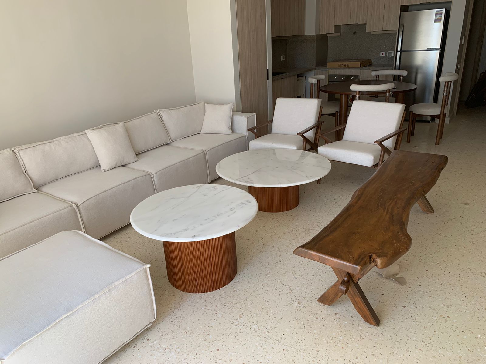 A cream modular sofa with marble coffee tables in an open-plan living space in Sheikh Zayed