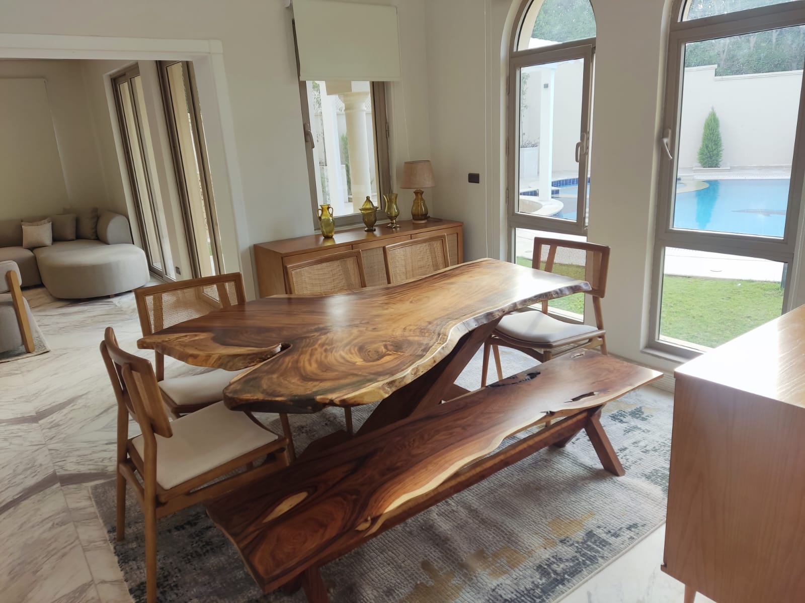 A live-edge walnut dining table with a matching bench delivered in New Cairo